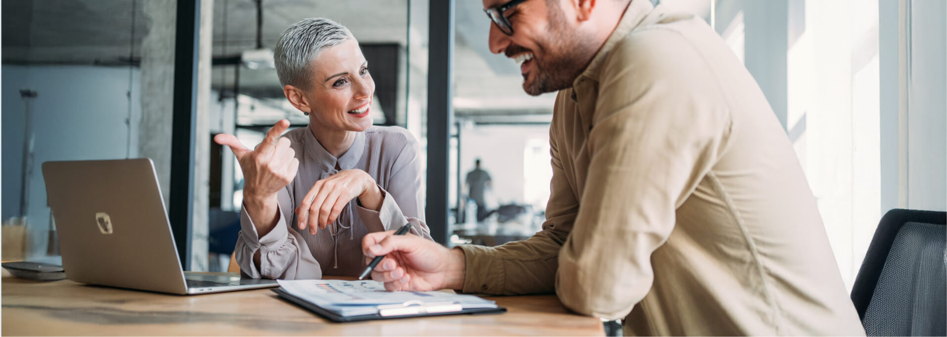 Zwei Personen sind in einem Businessmeeting und besprechen etwas.